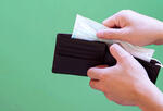 Image of someone pulling a mask out of a wallet.