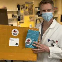 BWH healthcare worker with Masks 2 Heroes donation box.